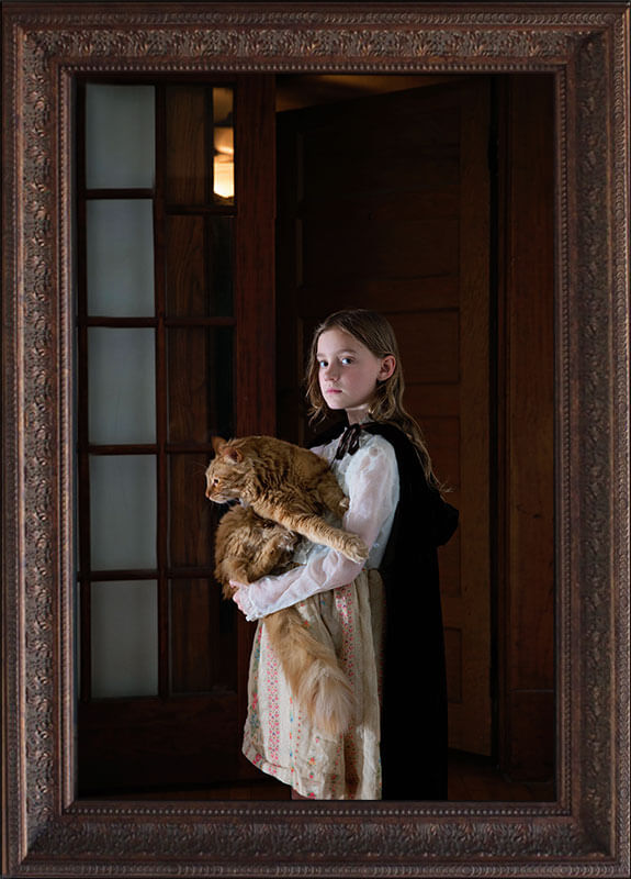 fine art portrait of little girl holding large orange cat
