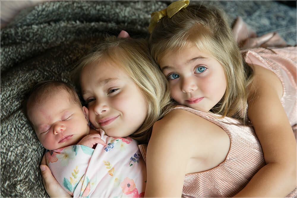 sisters with newborn baby